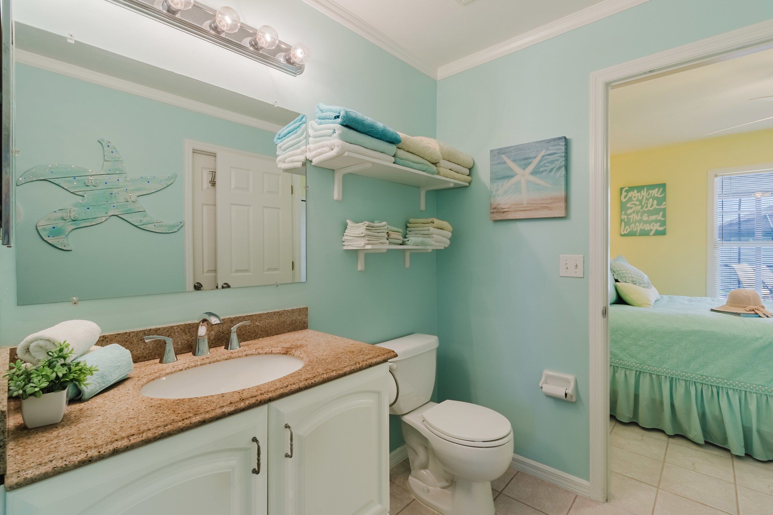 Une salle de bain équipée d’un lavabo, de toilettes et de porte-serviettes.