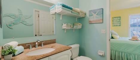 Une salle de bain équipée d’un lavabo, de toilettes et de porte-serviettes.
