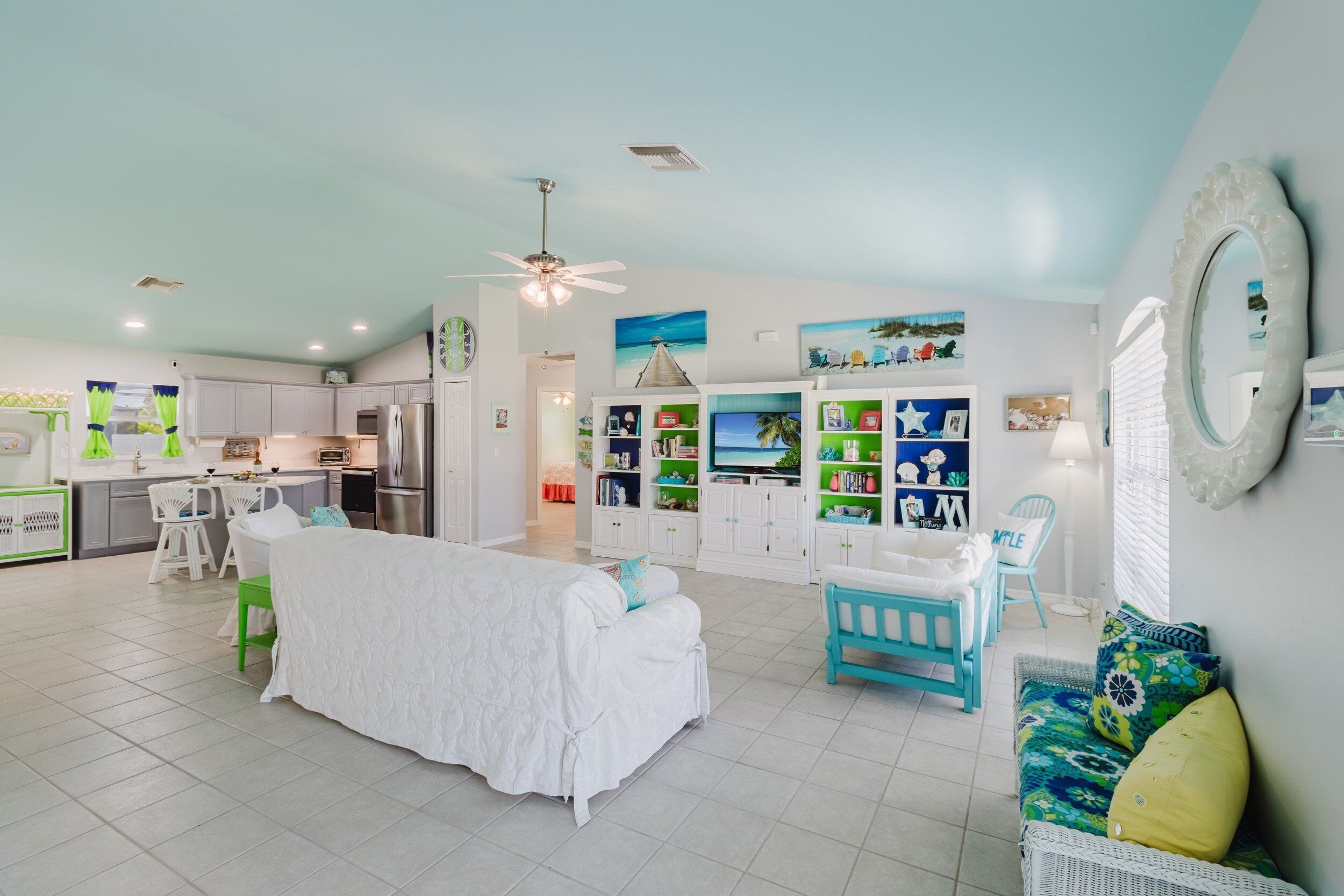 A spacious living area with a large bed, a dining table, and a kitchen in the background.