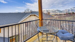 A balcony with a metal chair and table, overlooking a snowy mountain range. - Hot Tub & Mtn-View Deck: Townhome in Eden (Eden)