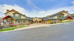 A row of green houses with stone foundations and wooden accents, connected by a central walkway. - Hot Tub & Mtn-View Deck: Townhome in Eden (Eden)