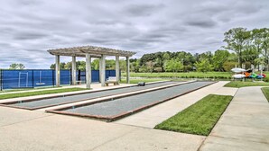 Une piscine dotée d’une pergola et d’un espace salon couvert.