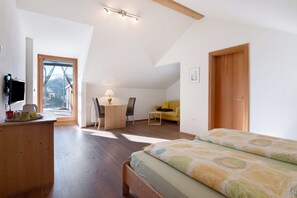 Un dormitorio con cama, escritorio, silla, sofá y televisor.