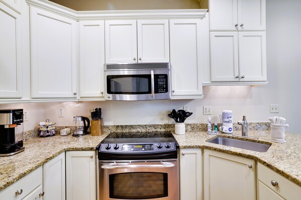 A kitchen with white cabinets, a stainless steel microwave, a gas stove, and a granite countertop. - Pop's Place-TwnHome for 14,Pool.Beach Ski/Tube just 1/4mile from our door! (Lake Harmony)
