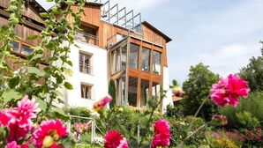 Ein zweistöckiges Gebäude mit großen Fenstern und einer Holzfassade.