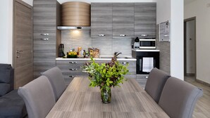 A modern kitchen with grey cabinetry, a built-in oven, and a microwave.
