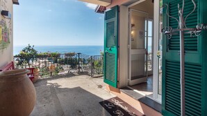 A balcony with a view of the sea, a door with green shutters, and a welcome mat. - Apartment 'Le Pale - Girasole' with Sea View, Wi-Fi and Air Conditioning (Bogliasco)