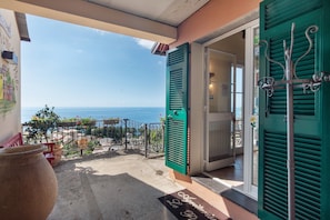 A balcony with a view of the sea, a door with green shutters, and a welcome mat. - Apartment 'Le Pale - Girasole' with Sea View, Wi-Fi and Air Conditioning (Bogliasco)