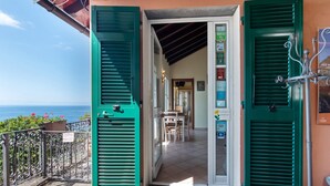 A coastal property with a terrace, green shutters, and a view of the sea. - Apartment 'Le Pale - Girasole' with Sea View, Wi-Fi and Air Conditioning (Bogliasco)