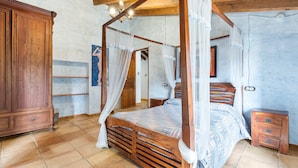 A four-poster bed with a canopy, wooden wardrobe, and a small bedside table. - Country House 'La Carrasca - Limón' with Shared Pool, Wi-Fi and Air Conditioning (Catral)