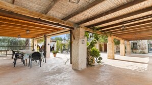 An open-air covered patio with a concrete floor, wooden beams, and potted plants. - Country House 'La Carrasca - Naranja' with Shared Pool, Wi-Fi and Air Conditioning (Catral)