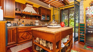 Una cocina con armarios de madera, una isla central y un refrigerador con imanes.