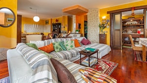Una sala de estar con sofá, una mesa de comedor y una zona de cocina.