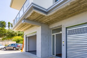 En bygning med to garageporte, en betonfacade og en klar himmel.
