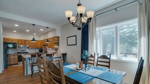Una cocina moderna con armarios de madera, una isla central e iluminación colgante.