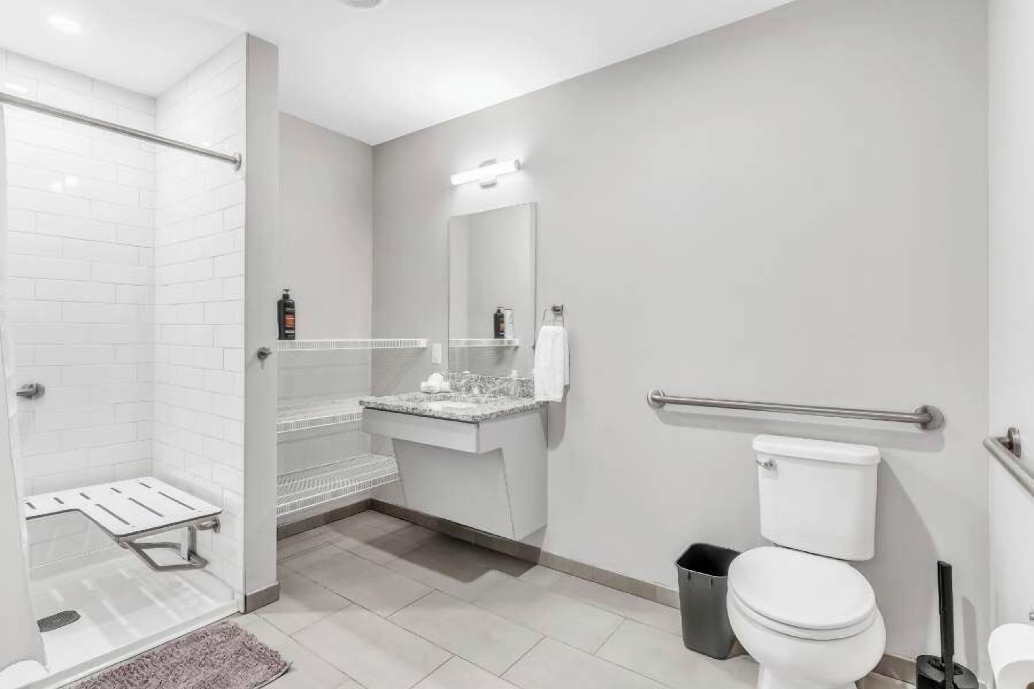 A modern bathroom with a shower, toilet, and vanity.