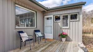 A covered porch with two chairs, a door, and a potted plant. - 5 min to the beach! Sun filled cottage in Turkey Point (Vittoria)
