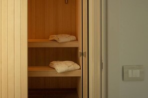 A wooden wardrobe with two shelves, each holding a folded towel. - Palazzo Indaco - RESIDENZA DIAMANTE (Castel di Sangro)