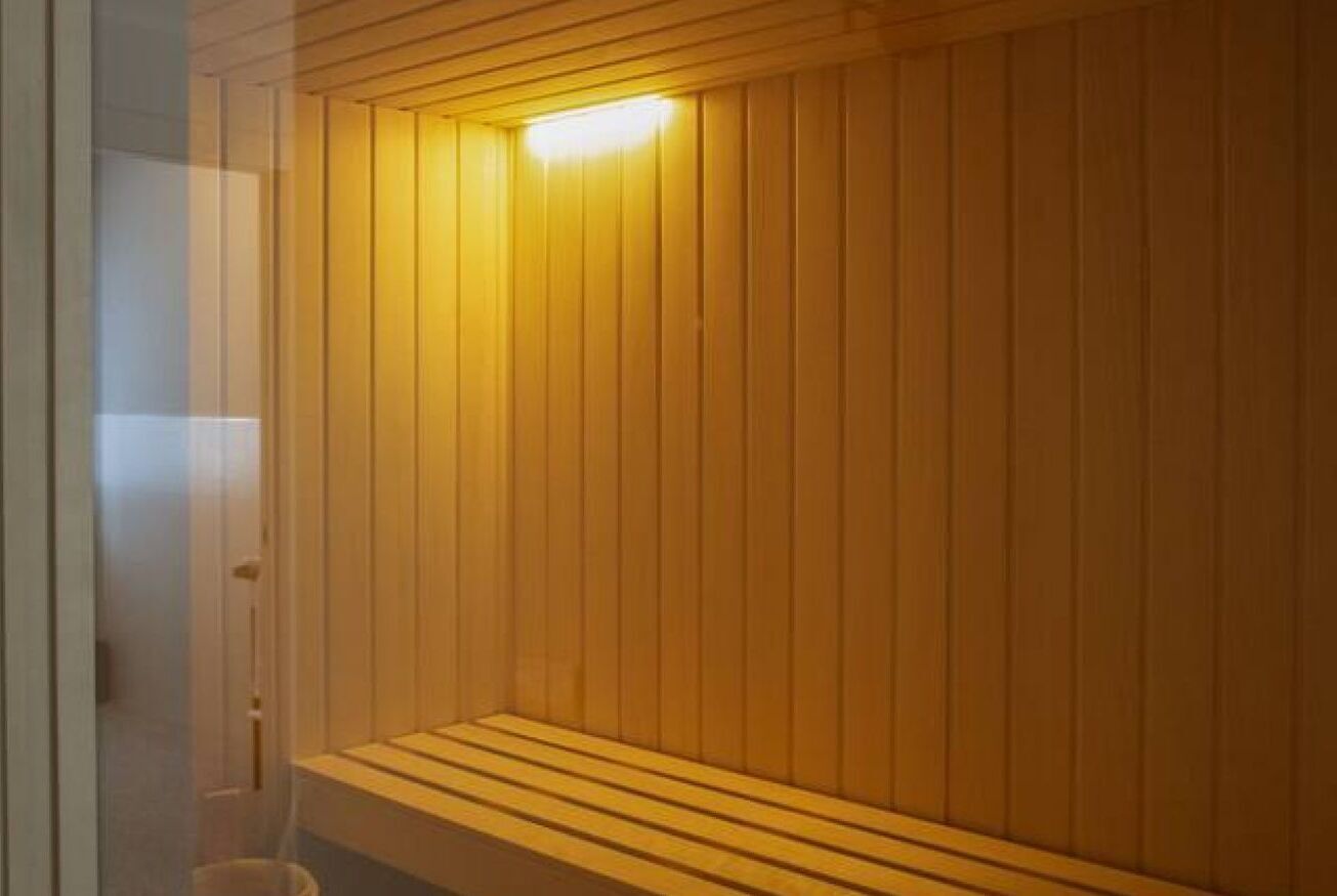 A sauna with wooden walls and a bench.