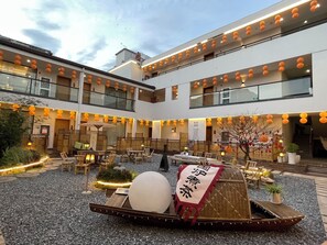 A courtyard with outdoor seating, lanterns, and a traditional boat. - Lin an Hot Spring Story Family Homestay (Hangzhou)