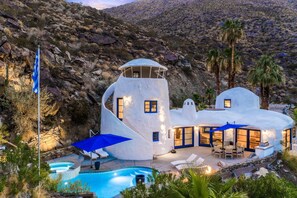 Una casa blanca y moderna con piscina y zona de estar al aire libre.