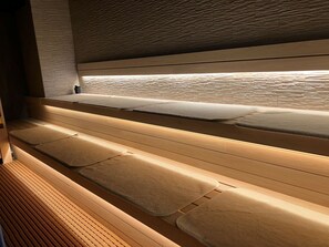 A modern interior with wooden paneling and a stone-textured wall. - HOTEL LiVEMAX Tendo (Tendo)