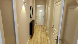 A hallway with wooden flooring, beige walls, and white doors. - Apartment center Carmes (Toulouse)