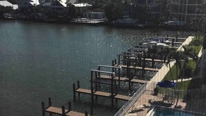 A waterfront hotel with a swimming pool, docked boats, and a view of the city skyline. - 1 bedroom plus STUDIO on Vanderbilt Beach. Beach access, water views. Sleeps 4 (Naples)