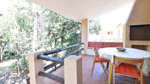 A patio with a round table, chairs, and a grill. - Cottage with a/c two bedrooms and two bathrooms (Aglientu)