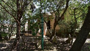 A pathway leading to a building surrounded by trees and rocks. - Cottage with a/c two bedrooms and two bathrooms (Aglientu)