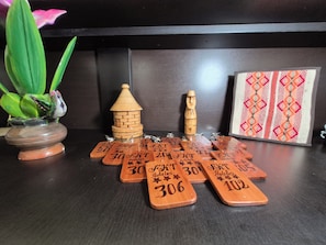 A wooden table with numbered wooden plaques labeled 'FHT Hoteles' and decorative items including a bird figurine, a small house, and a vase with a plant.
