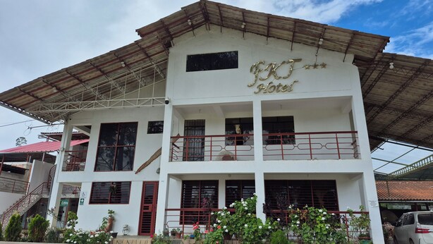A two-story building with a sign reading "HOTEL" and a balcony with red railings.