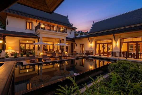 A modern resort with a swimming pool, outdoor seating, and traditional architecture.