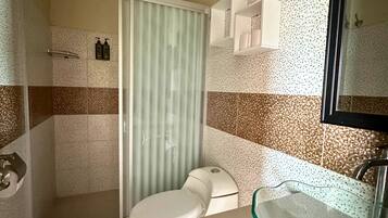 Tweepersoonskamer, uitzicht op tuin | Badkamer | Een douche, handdoeken, zeep, shampoo