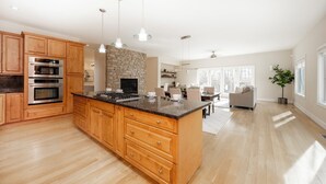 A spacious kitchen with wooden cabinets, stainless steel appliances, and a large island.