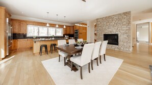 A spacious kitchen with wooden cabinets, a central island, and pendant lighting.