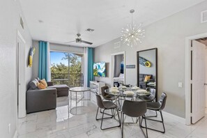 Relax in this stylish living area with a sofa, dining table, and TV, perfect for unwinding.