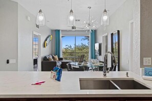 Enjoy meals in this well-equipped kitchen with a central island, stove, and pendant lights.
