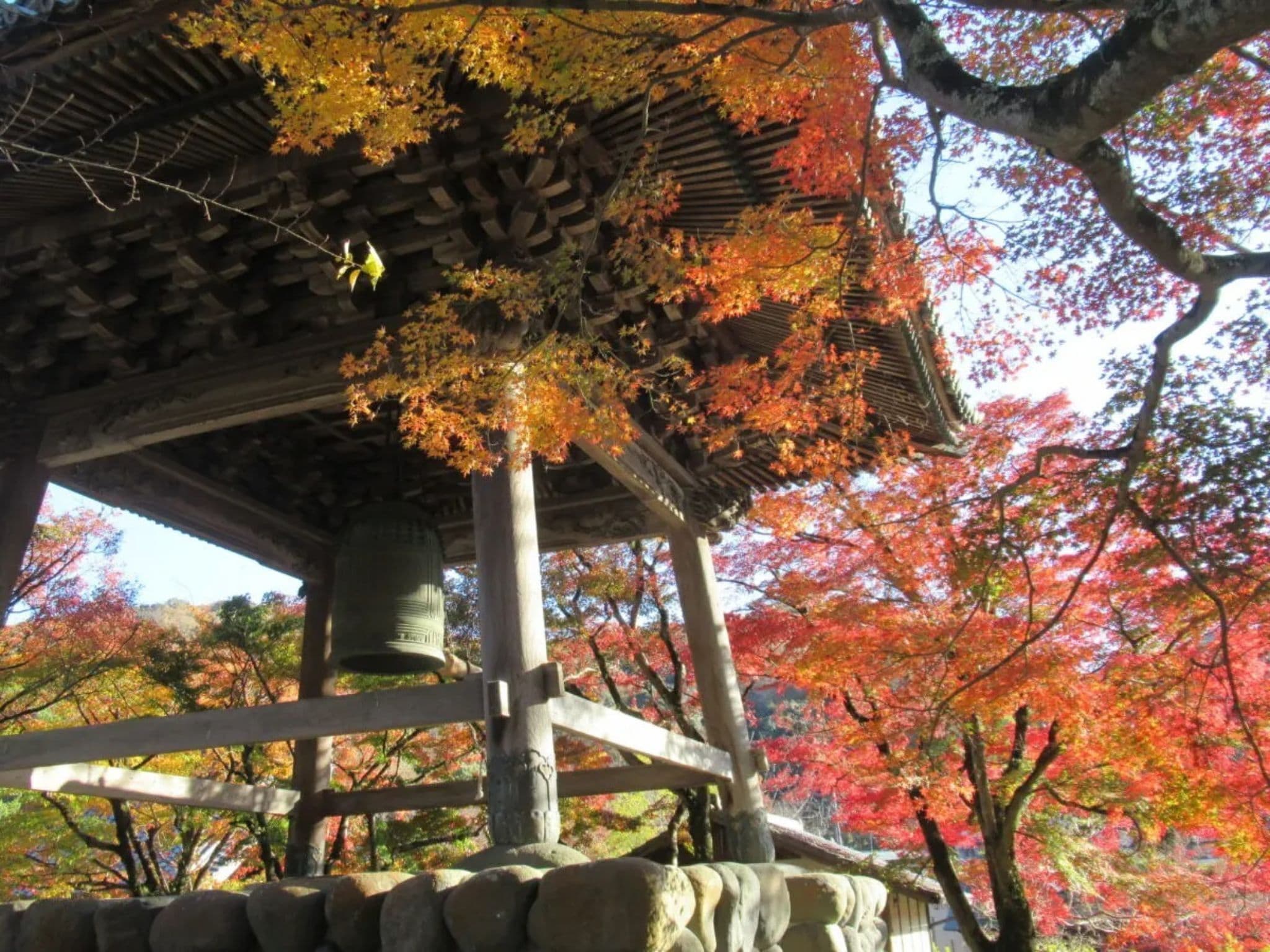 Perinteinen japanilainen paviljonki, jossa on kivijalusta, puupalkit ja laattakatto.
