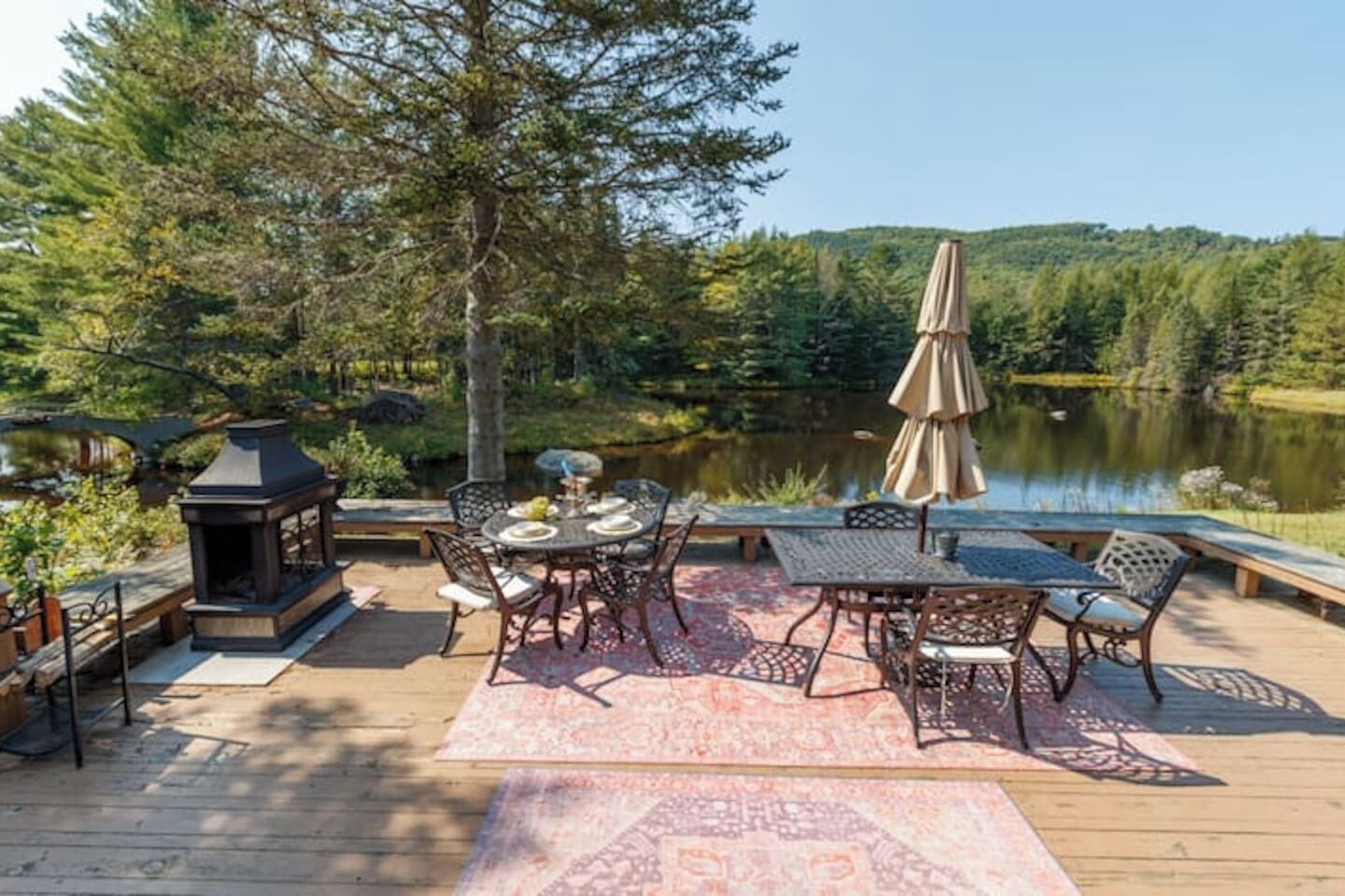 A deck with outdoor furniture, a table, chairs, and a lantern.