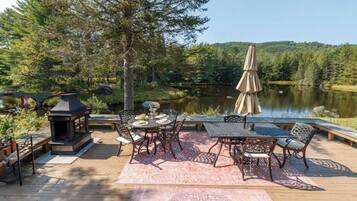 A deck with outdoor furniture, a table, chairs, and a lantern.