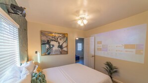 A bedroom with a bed, a projector screen displaying streaming services, and a ceiling fan. - Quiet Yet Close To Restaurants, Downtown, Coronado (San Diego)