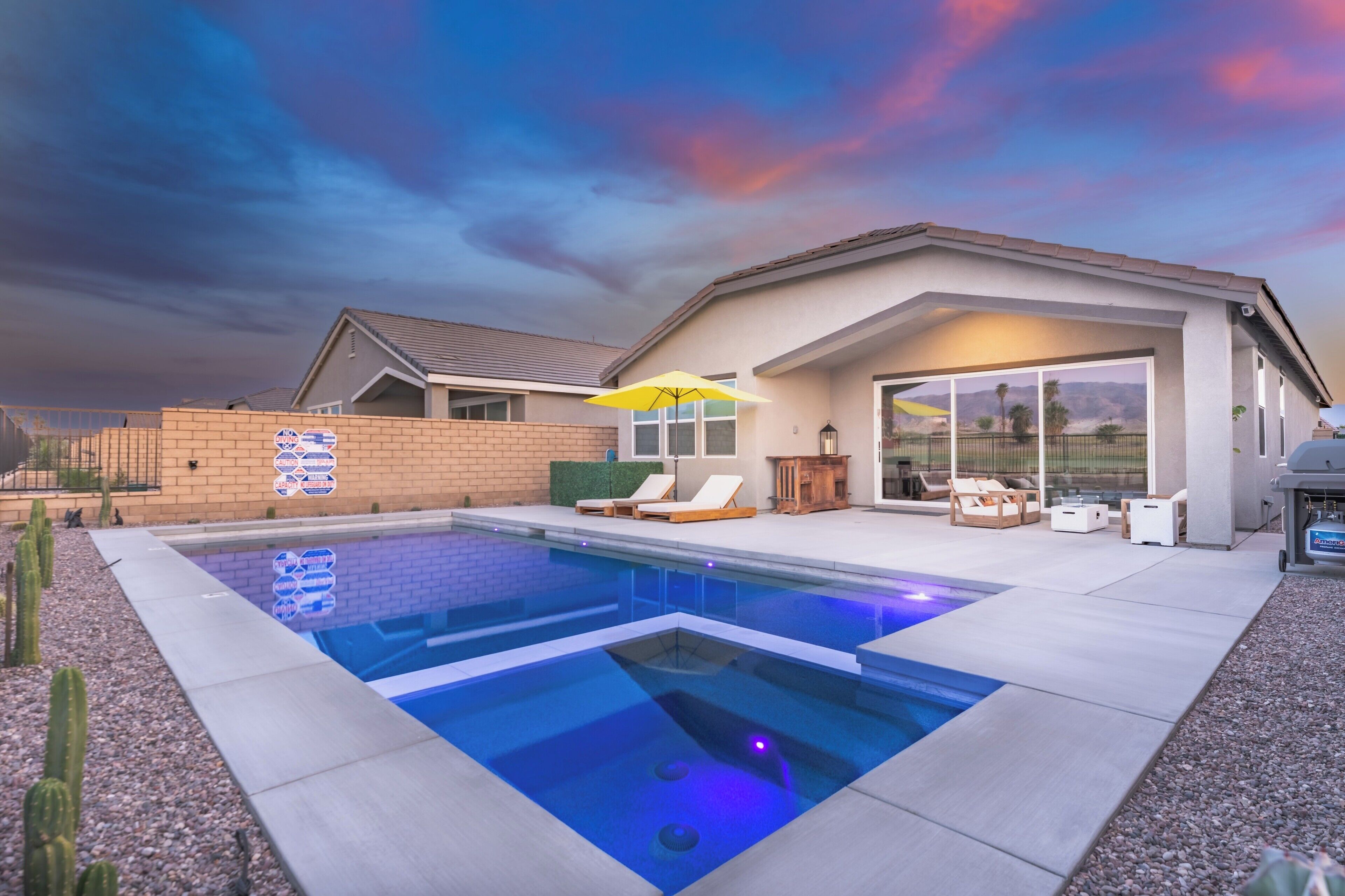 Una casa moderna con piscina, mobiliario exterior y un garaje amplio.