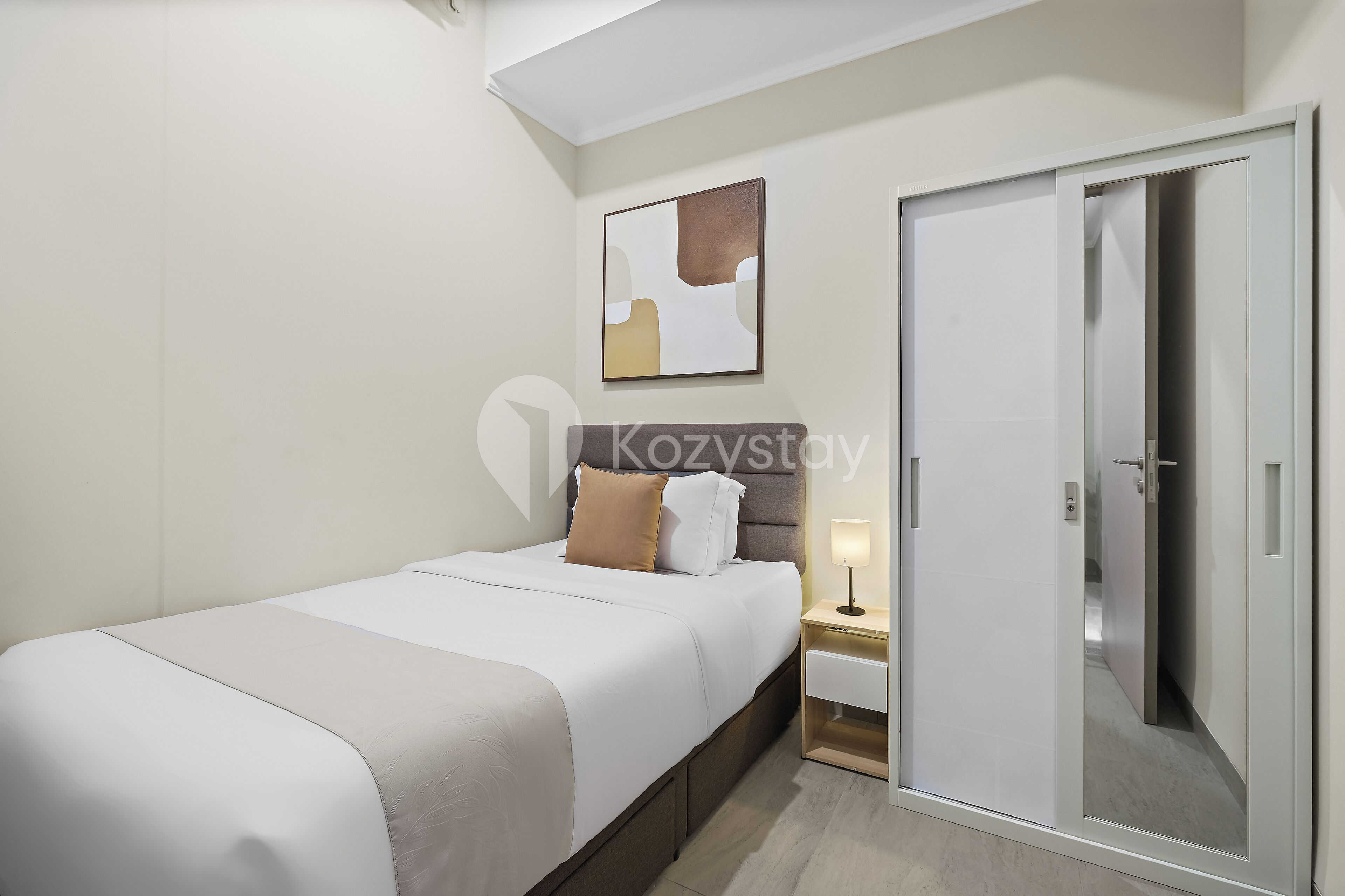 A hotel room with a bed, bedside table, lamp, and a sliding door.