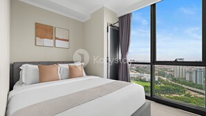 A modern bedroom with a large bed, a city view, and two abstract wall art pieces. - Serora by Kozystay - Kemayoran (Jakarta)