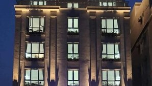 A hotel with a modern facade, large windows, and a neon sign. - Aqua Resort Hai Tien - by BAYLUXURY (Hoang Tien)