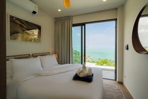 A hotel room with a large bed, a view of the sea, and a painting on the wall. - Staylar Seaview Pool Villa - Coral Cove, Koh Samui CC2 (Koh Samui, Coral Cove)
