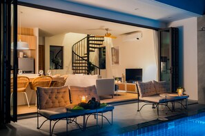 Una sala de estar moderna con piscina, escalera y comedor.