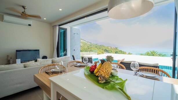 A modern kitchen with a dining area, a TV, and a view of the sea. - Staylar Seaview Pool Villa - Coral Cove, Koh Samui CC2 (Koh Samui, Coral Cove)
