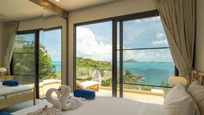 A hotel room with a large bed, a view of the sea, and a balcony with a chair. - Staylar Seaview Pool Villa - Coral Cove, Koh Samui CC1 (Koh Samui, Coral Cove)